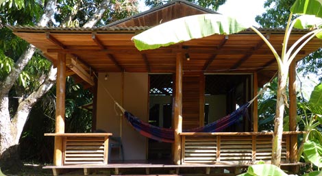 Wooden bungalow with hammock at Luz de Luna hotel in Santa Teresa Costa Rica surrounded by tropical vegetation