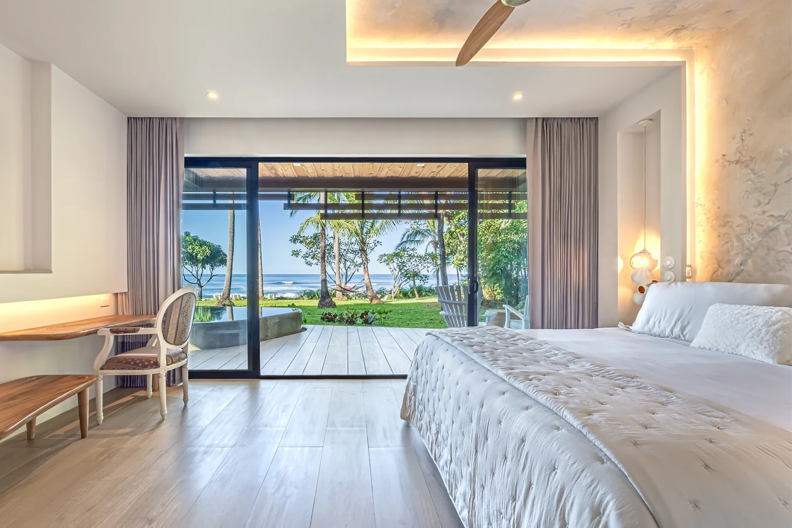 Chambre lumineuse ouverte sur un jardin tropical et l’océan